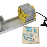 Metal workbench vise with power tool and instruction manual on a white background