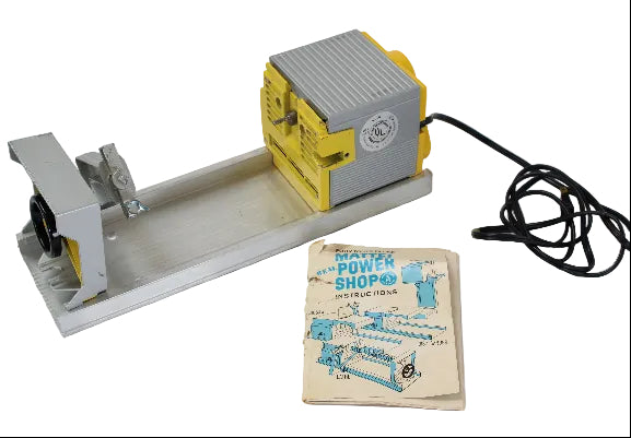 Metal workbench vise with power tool and instruction manual on a white background
