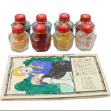Set of small bottles with red caps and a colorful illustration on a white background