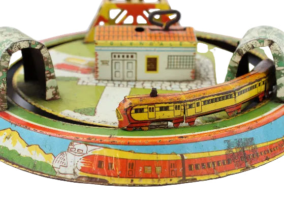 Vintage toy train set with colorful track and buildings on a white background