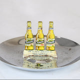 Three Senate Ale bottles on a metallic tray with a white background