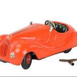 Red toy car with a key on a light gray background