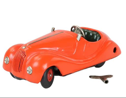 Red toy car with a key on a light gray background