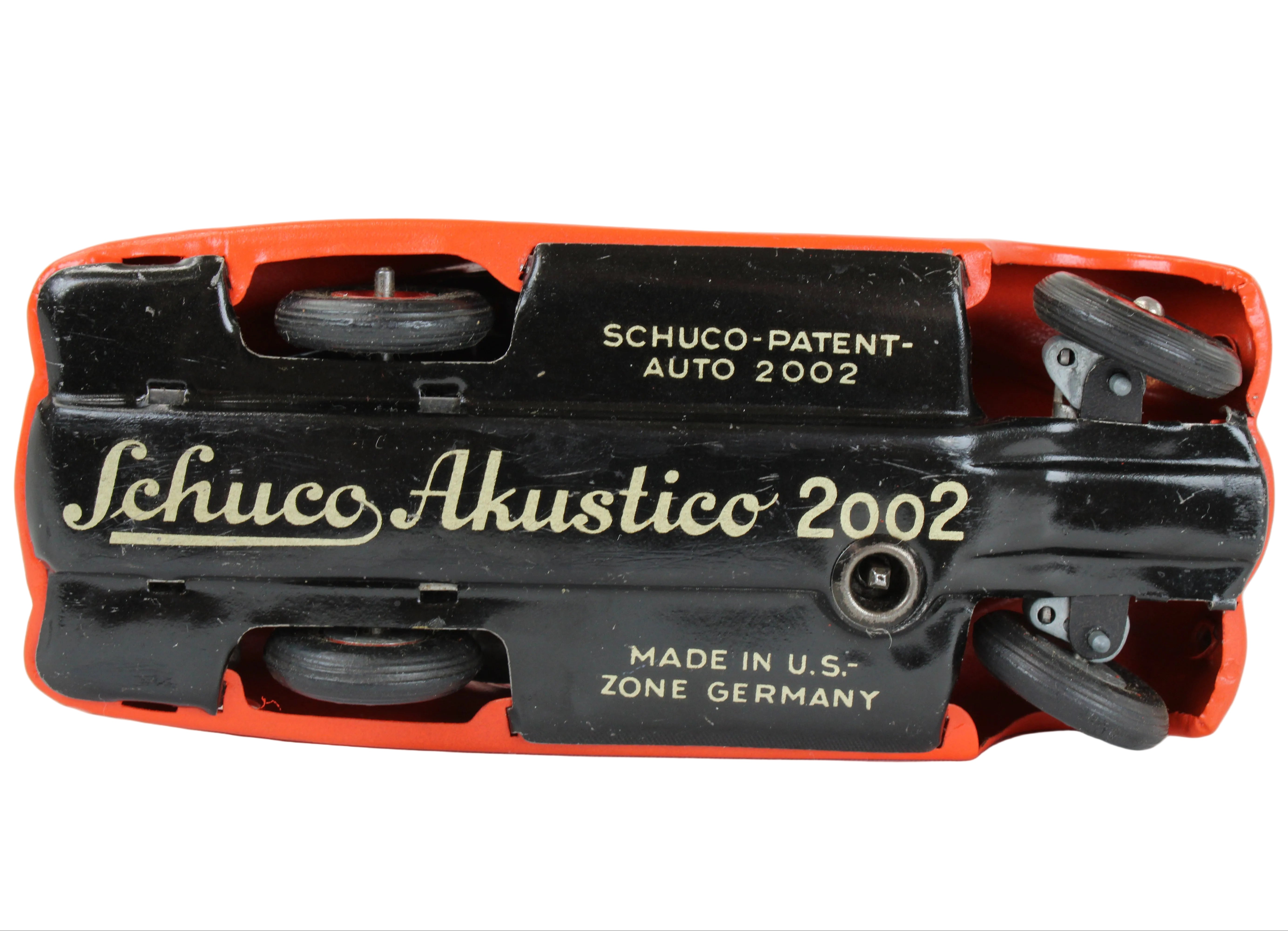 Schuco Akustico 2002 toy with red casing and black details on a white background