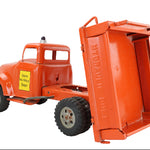 Model of a red dump truck with an open bed on a white background