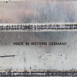 Text 'MADE IN WESTERN GERMANY' on a textured surface