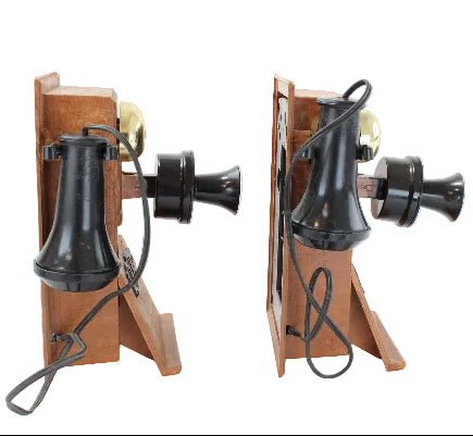 Two vintage-style telephones with wooden bases and black mechanical parts on a white background.