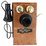 Vintage wooden telephone with black and gold components on a white background
