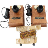Two vintage wall-mounted telephones with coiled wires on a white background