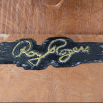 Wooden box with 'Roy Rogers' logo in gold on a wooden background