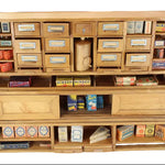 Wooden cabinet with shelves displaying various model train accessories on a white background