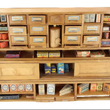 Wooden cabinet with shelves displaying various model train accessories on a white background