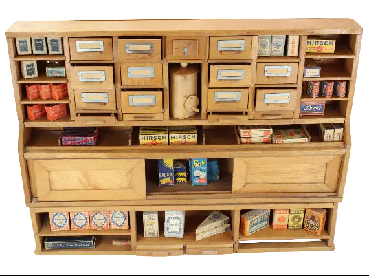 Wooden cabinet with shelves displaying various model train accessories on a white background
