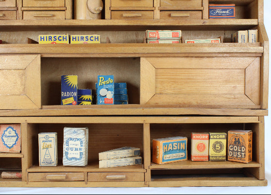 Wooden shelf with vintage toy boxes and packaging on a white background