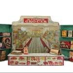 Miniature model of a grocery store with 'The Corner Grocer' sign and various products on shelves.