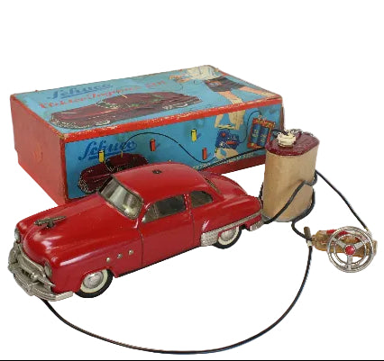Red toy car with a pull string and its box on a white background