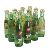 Collection of green glass bottles with gold caps on a white background