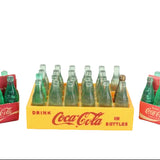 Set of miniature Coca-Cola bottles in vintage packaging on a white background
