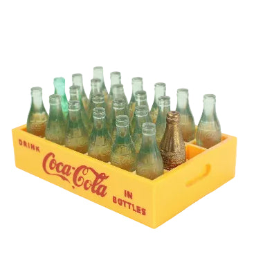 Collection of vintage Coca-Cola bottles in a yellow crate on a white background