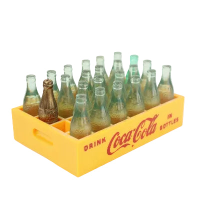 Collection of vintage Coca-Cola bottles in a yellow crate on a white background