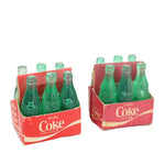 Two packs of green miniature Coca-Cola bottles in red cardboard boxes on a white background