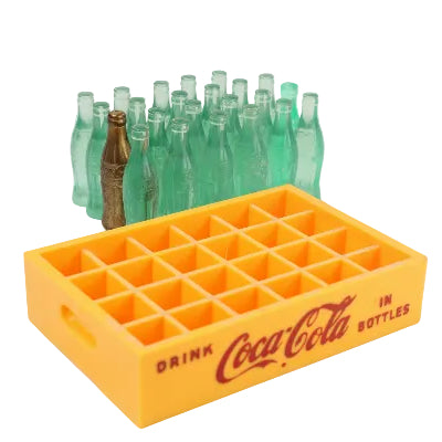 Yellow Coca-Cola miniature bottle crate with green glass bottles on a white background
