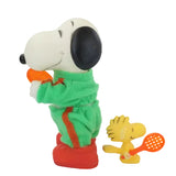 Snoopy and with a green outfit and red shoes and Woodstock on a white background