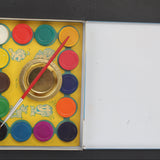 Set of Blondie watercolor paints with a brush in an open box on a dark background