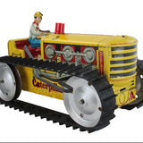 Toy Caterpillar tractor with a driver figure on a white background