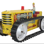 Toy Caterpillar tractor with a driver figure on a white background