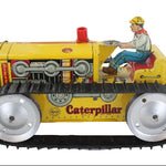 Vintage toy Caterpillar tractor with a driver figure on a white background