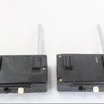 Two black electronic devices with antennas on a white background