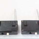 Two black electronic devices with antennas on a white background