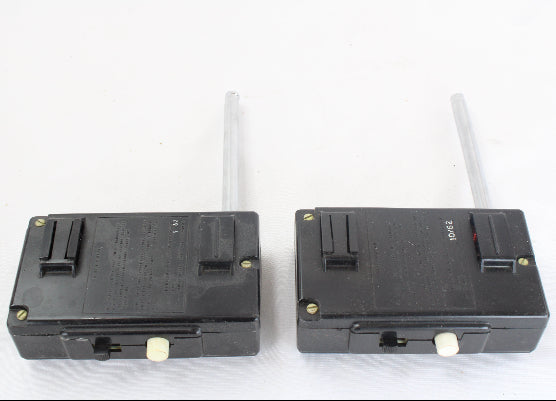 Two black electronic devices with antennas on a white background