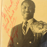 Vintage photograph of boxer Joe Frazier with a championship belt and signature on a yellowed background