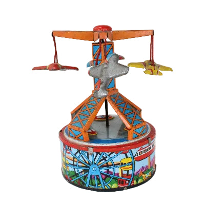 A vintage toy wind-up carousel with a colorful base depicting a fairground scene, featuring a rotating orange and blue structure with small toy airplanes and a gray carousel horse.