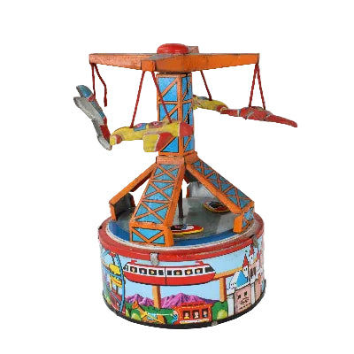 A vintage toy carousel or spinning ride with colorful painted metal details, photographed against a plain white studio background.