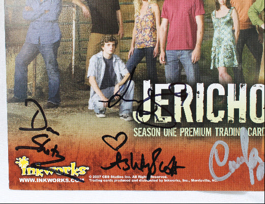 An autographed Jericho Season One trading card from Inkworks Studios, featuring the cast on the front with signatures in black, blue, and white marker across the lower portion.
