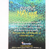 A rectangular printed card or cover with a textured green and blue surface, featuring vertical text including 'Coming May 1998' and smaller text about availability. The card is photographed against a plain white background.
