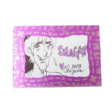 A rectangular printed card or sticker with a pink and purple patterned border, featuring a black line drawing of a smiling anime-style character and the word 'SHAGGY' with a heart and the name 'Chiguma' below, placed on a dark textured background.